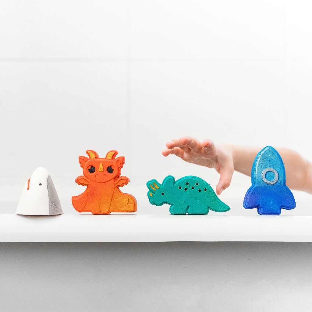 Selection of four bath bombs and child's hand reaching for one