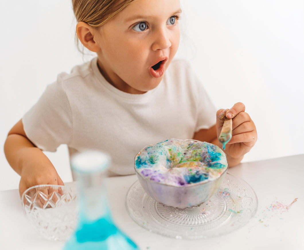 Girl looking surprised and amazed as a fizzing potion starts to rise up in a bowl