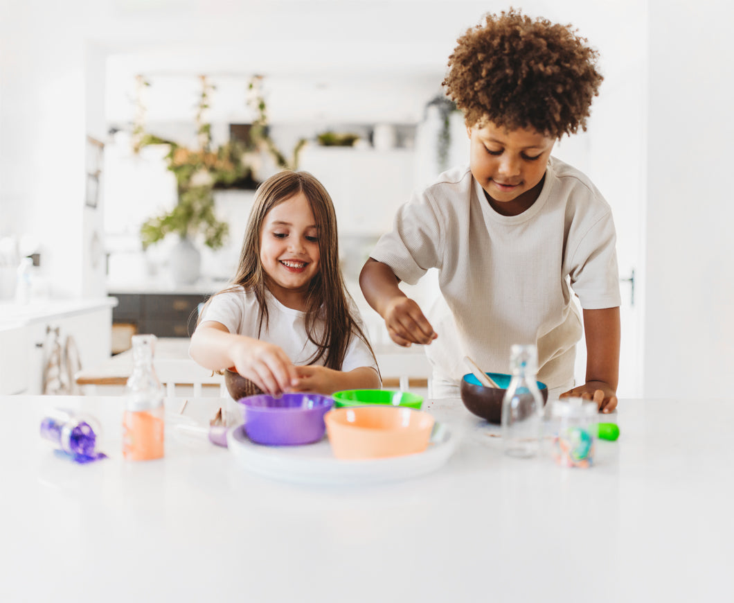 Two children playing with potions at a table