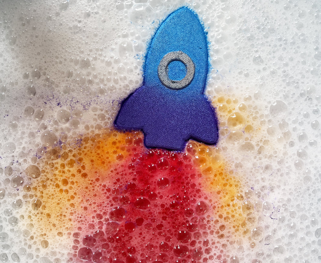 Rocket-shaped bath bomb with red and yellow coloured water coming from the bottom like flames