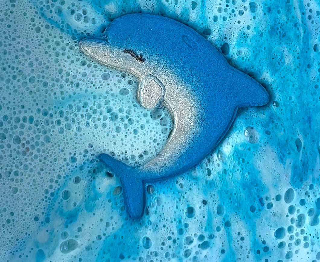Dolphin shaped bath bomb fizzing and making the water blue with bubbles