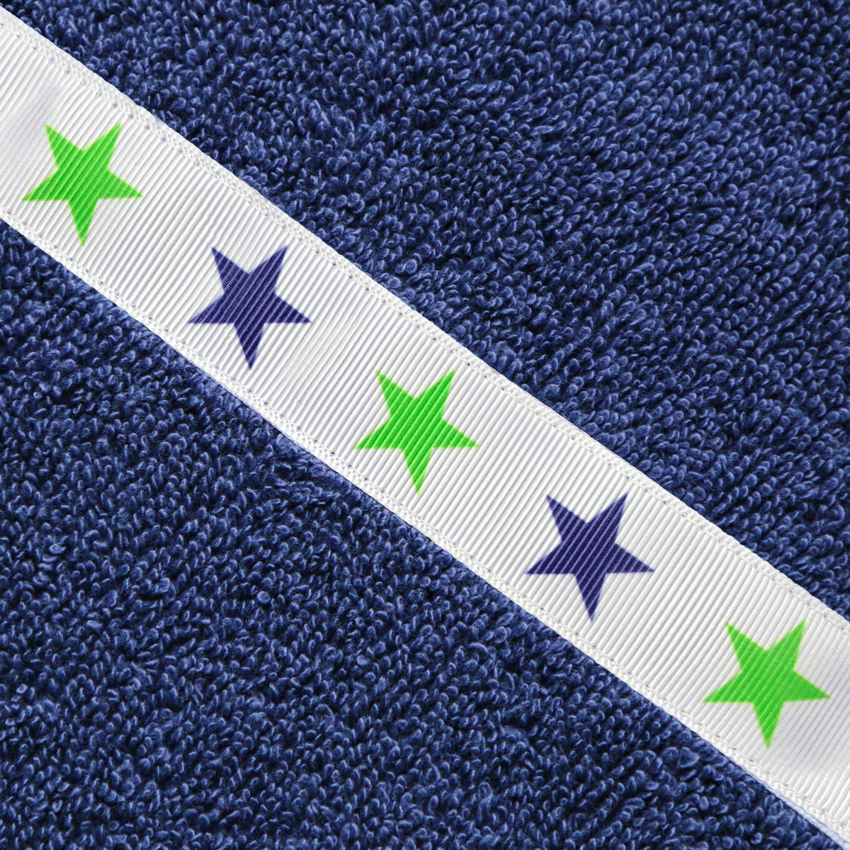 Close up of the Green Stars trim on a navy blue hooded towel